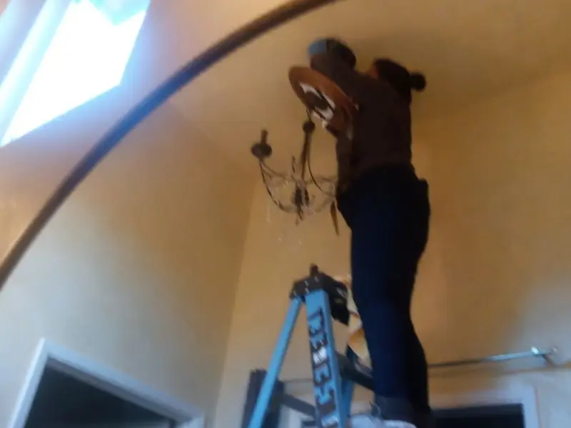 Electrician installing a chandelier in a Florin residence